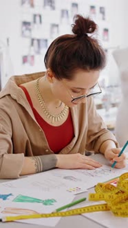 Young Female Fashion Designer Working with New Clothes Collection Working at Tailor Showroom