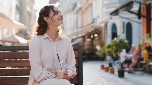 Woman Enjoying Drinking Morning Cold Coffee Drink with Ice Relaxing Taking a Break in City Street