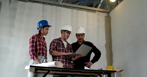 Un groupe de jeunes architectes en bâtiment asiatiques et ingénieurs en construction se réunit