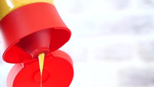 Yellow Mustard Being Squeezed from Bottle, Macro