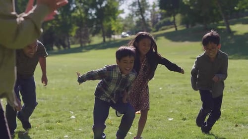 Happy multigenerational family running and racing in sunny autumn park