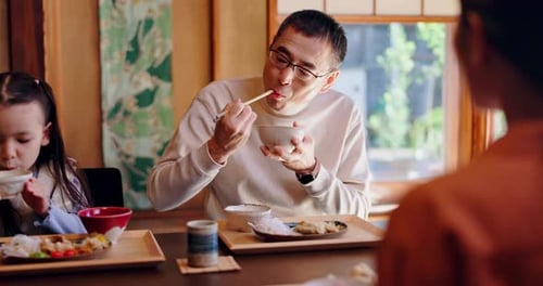 Father and Daughter Eating Meal Together at Home