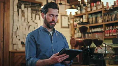 Handsome Waiter Smiling at Camera While Standing at Bar with Digital Tablet