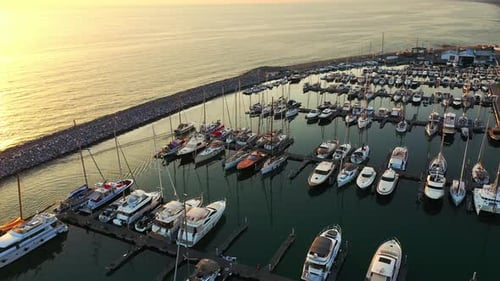 Aerial Drone Footage: Flight Over Marina Bay with Yachts of Different Sizes. Luxury Yachts and Fish