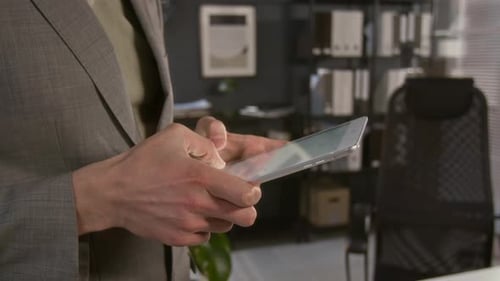 Hands of Unknown Office Manager Typing on Digital Tablet during Workday