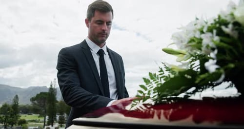 Man, casket and touch for respect at funeral with grief, goodbye and outdoor at cemetery