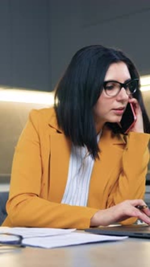 Woman in Blazer on Mobile Phone Writing Notes