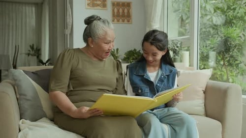 Grandmother and Granddaughter Looking at Photo Album
