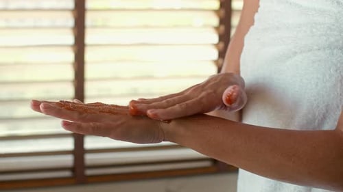 Person Applying Exfoliating Scrub to Hands