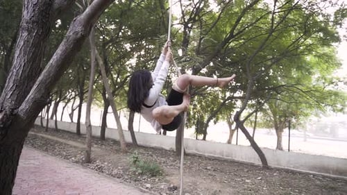 A sporty gymnast performs exercises with a rope in sportswear.Concept: power, strength, healthy life