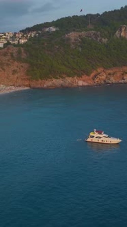 Coastal Town with Yacht Anchored in Turquoise Sea