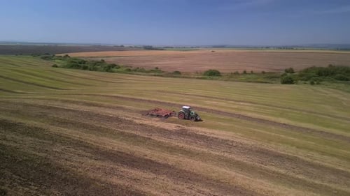 Tractor working on the field doing tillage with cultivator