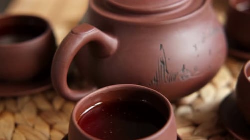 Cerimônia do chá: utensílio de chá asiático tradicional que serve um conjunto autêntico, pessoa servindo chá marrom