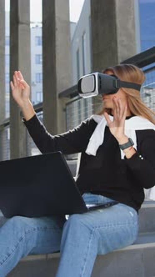 Woman Experiencing Virtual Reality with Laptop on Steps