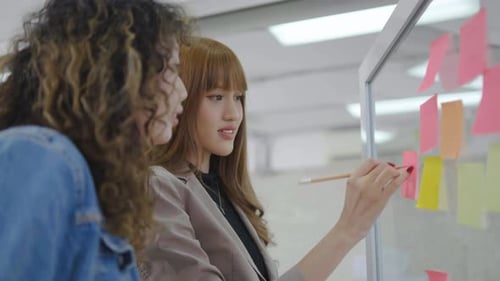 Women Collaborating, Writing on Sticky Notes in Office