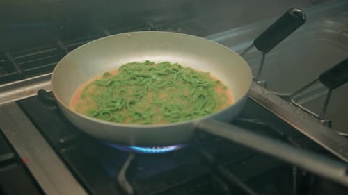 Tagliatelle Green Colored Pasta Cooking In The Pan Of A Restaurant