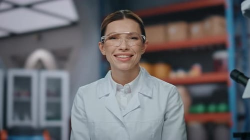 Smiling Scientist in Lab Coat and Safety Glasses
