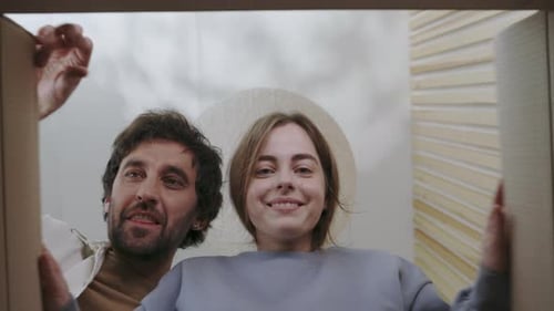 Couple Opening Delivery Box With Joyful Reaction