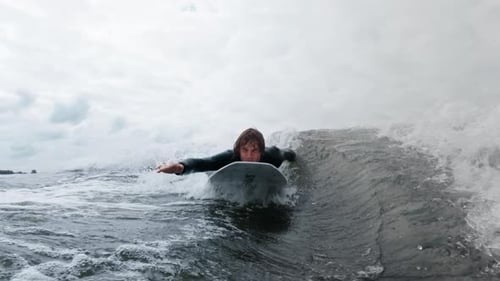 Surfer Gliding Through Ocean Waves Showcasing Dynamic Motion and Water Splashes