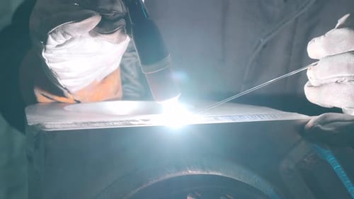 Professional welder works in a room with slow motion
