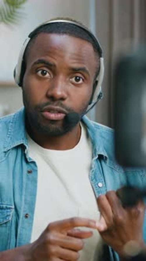 Close Up of Handsome Concentrated Professional Bearded African American Blogger Man in Headset Which