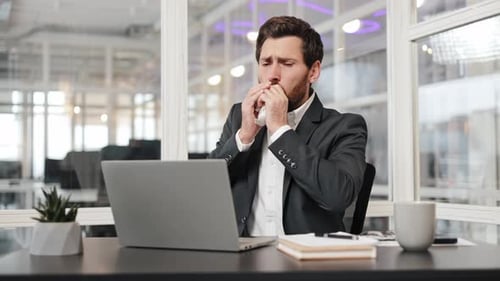 Sick Businessman Coughing at Work in Office