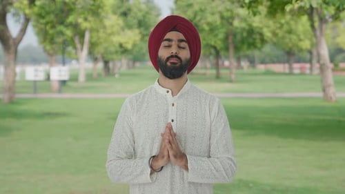 Religious Sikh Indian man praying to God in park