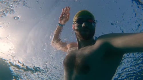Hombre nadando estilo libre en el agua del mar