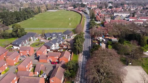 Flying over small provincial town, aerial view. Beautiful scenery of street playground in the city.
