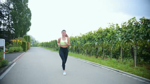 Woman Running on Country Road Through Vineyard