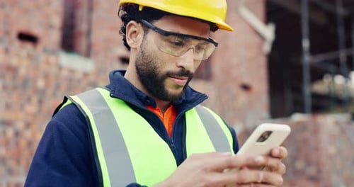 Man, typing and phone on construction site with schedule, building app and happy for progress