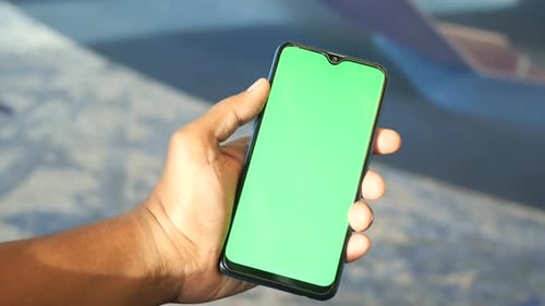 Young Man Hand Using Smart Phone with Green Screen at Cafe