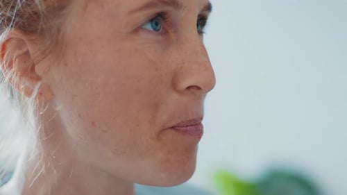 Healthy drink. Redhead woman drinks healthy green cocktail on the modern kitchen