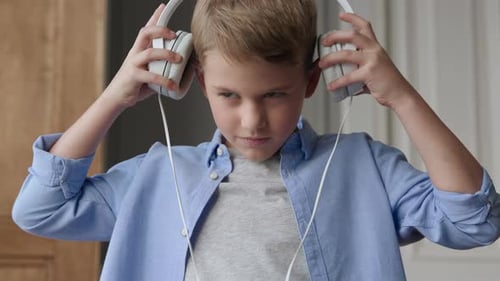 Smiling boy enjoying music with headphones in his home room canon cinema eos