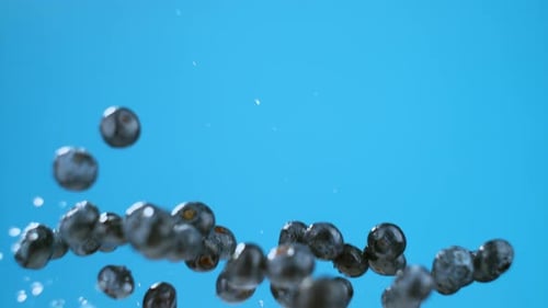 A bunch of wet blueberries flying through the frame. High quality cinematic studio commercial super