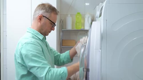 Man Unloads Clothes From Washing Machine