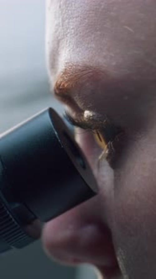 Female Biochemist Looks Under Microscope Does Analysis of Sample Macro Close Up