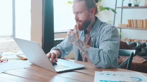 Joven caucásico trabaja como programador escribiendo código en una computadora portátil para un nuevo software