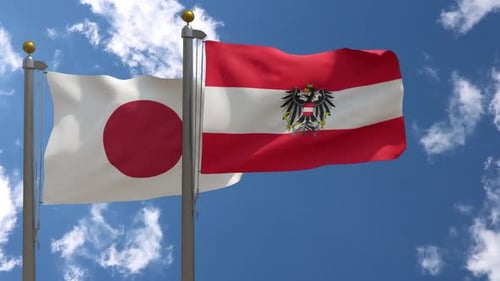 Flags of Japan and Austria Waving on a Blue Sky