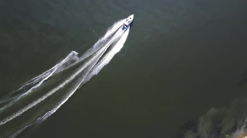 A Young Man is Skiing A Sports Guy is Skiing on the Water Behind a Boat Top View From a Drone