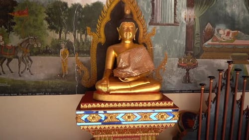 Peaceful golden buddha statue with religious paintings in the background in a Buddhist Temple. Chian