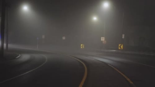 Vehicles Driving On Foggy Road At Night - wide