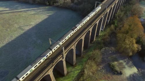 Commuter Train Passing Over a Beautiful Viaduct in the Evening