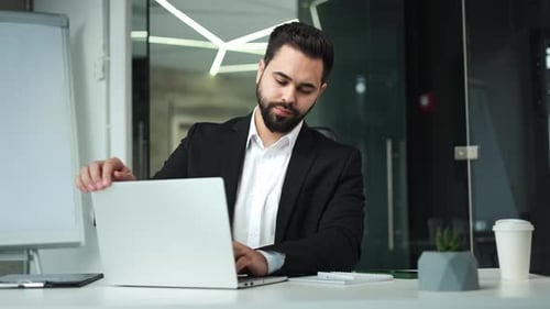 Man Meditates at Desk in Modern Office