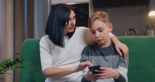 Woman and Boy Using Mobile Phone Together