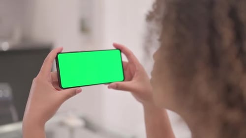 African American Woman Holding Phone with Chroma Key Screen