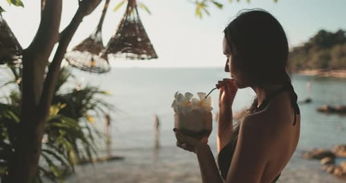 Woman Drinks Coconut Cocktail on Tropical Beach