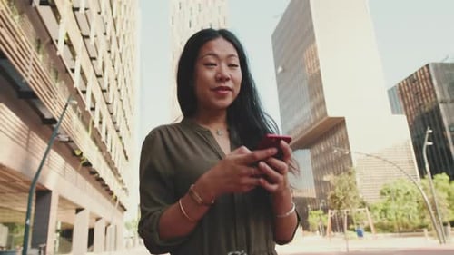 Woman Using Phone on City Street