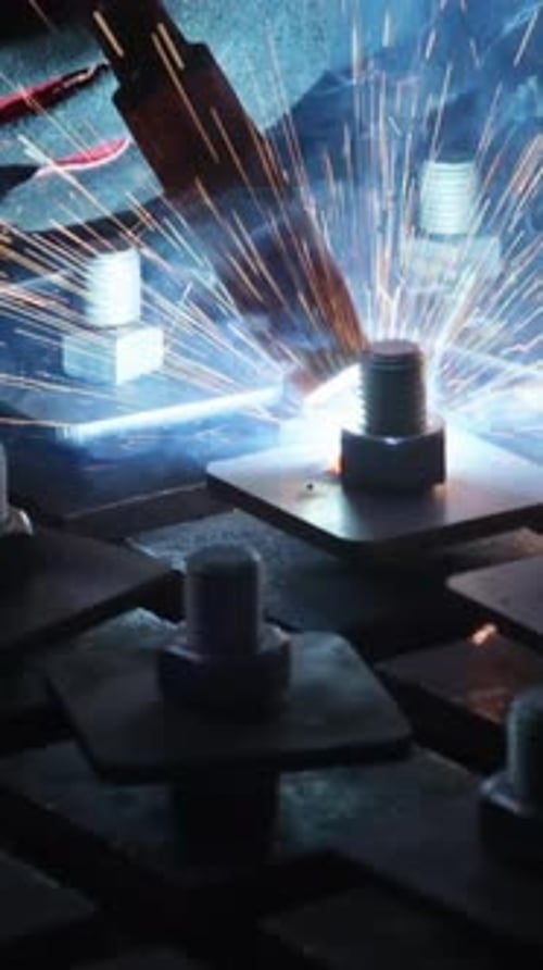 Heavy Industry Worker in Protective Mask Welds Steel and Other Products in a Factory Environment