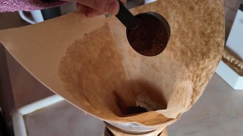 Coffee Grounds Poured Into Paper Coffee Filter